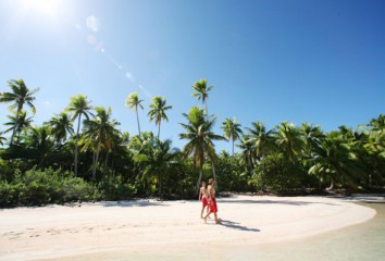 Couple en train de marcher sur une plage polynésienne
